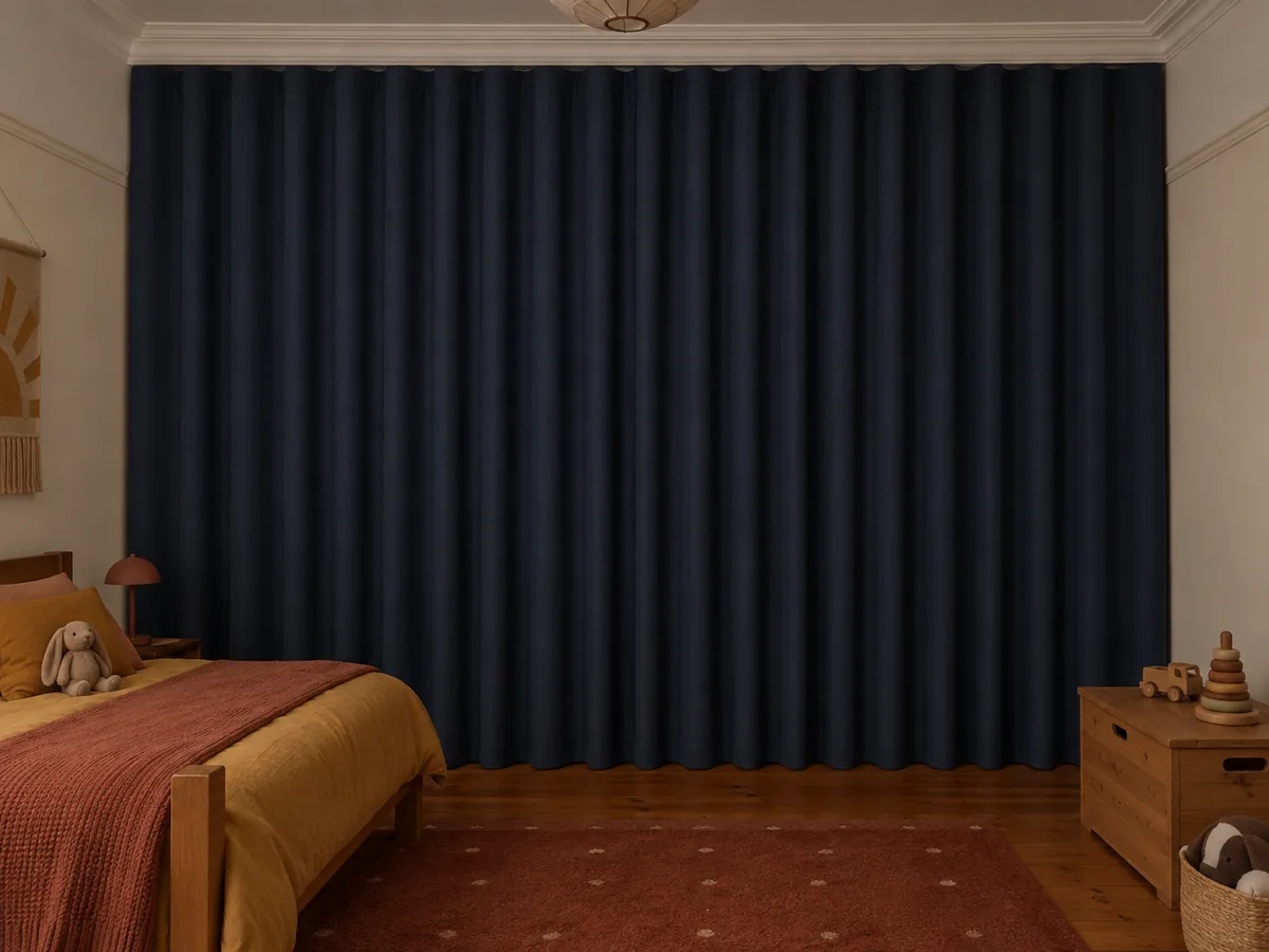 Navy blockout curtains fully closed over a tall window in a period kids' bedroom