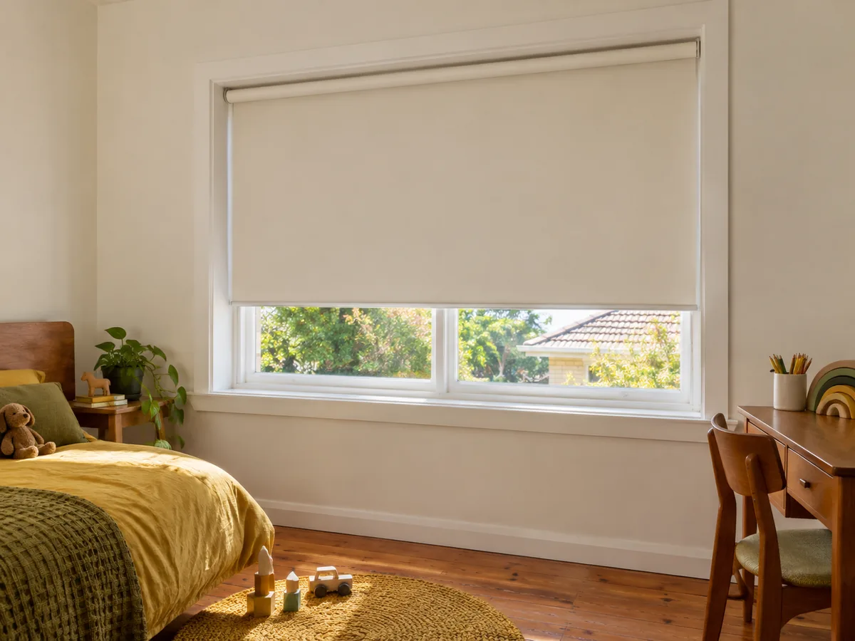 Warm-white blockout roller blind recess-fitted in a deep window reveal in a kids' bedroom